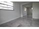 Bright bedroom with large windows, gray tile floors, and ample closet space at 5641 Quist Dr, Port Richey, FL 34668