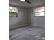 Cozy bedroom with gray tile floors, natural light from two windows, ready for personalization at 5641 Quist Dr, Port Richey, FL 34668