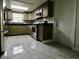 Well-lit kitchen with stainless steel appliances, gray cabinets, and gray tile flooring at 5641 Quist Dr, Port Richey, FL 34668