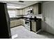 Well-lit kitchen with stainless steel appliances, granite counters and grey shaker cabinets at 5641 Quist Dr, Port Richey, FL 34668