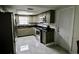 Well-lit kitchen with stainless steel appliances, gray cabinets, and gray tile flooring at 5641 Quist Dr, Port Richey, FL 34668