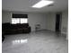 Inviting living room with plenty of space, gray tile floors, natural light, and a leather sofa at 5641 Quist Dr, Port Richey, FL 34668