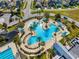 Aerial view of community pool and splashpad with palm trees and lounge chairs at 9173 Shadyside Ln, Land O Lakes, FL 34637