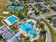 Aerial view of community amenities: pools, tennis courts, green spaces, and neighborhood street layout at 9173 Shadyside Ln, Land O Lakes, FL 34637