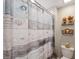 Cozy bathroom with a decorative shower curtain and wooden shelf accents at 9173 Shadyside Ln, Land O Lakes, FL 34637