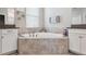 Elegant bathroom featuring a large soaking tub with decorative tile surround and granite countertops at 9173 Shadyside Ln, Land O Lakes, FL 34637