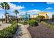 Community commercial building featuring colorful exterior, manicured landscaping, and paved walkway at 9173 Shadyside Ln, Land O Lakes, FL 34637