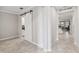 Bright hallway with gray tile flooring and a sliding barn door to an adjacent space at 9173 Shadyside Ln, Land O Lakes, FL 34637