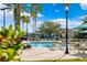 Community pool with lounge chairs, umbrellas and palm trees on a sunny day at 9173 Shadyside Ln, Land O Lakes, FL 34637