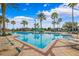 Community pool featuring clear blue water, lounge chairs, palm trees, and splash area at 9173 Shadyside Ln, Land O Lakes, FL 34637