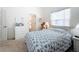 Cozy bedroom with a light blue quilt, ensuite, and natural lighting from the window at 1203 Clays Trl # 406, Oldsmar, FL 34677