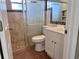 A bathroom is equipped with a shower, toilet, and vanity with neutral tones for a modern appeal at 13637 Lagoon Dr, Hudson, FL 34667