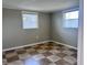 A bedroom showcasing tile flooring and natural light from two windows, creating a warm and inviting atmosphere at 13637 Lagoon Dr, Hudson, FL 34667