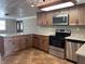 Well-lit kitchen featuring stainless steel appliances, a granite countertop, and wood cabinets at 13637 Lagoon Dr, Hudson, FL 34667