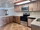 Well-lit kitchen featuring stainless steel appliances, a granite countertop, and wood cabinets at 13637 Lagoon Dr, Hudson, FL 34667
