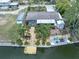 Aerial view of canal-front home with manicured yard, dock, fire pit, and enclosed patio at 14124 Kulig Ct, Hudson, FL 34667
