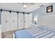 Bedroom featuring large barn doors, blue walls, and nautical decor at 14124 Kulig Ct, Hudson, FL 34667