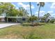 Well-maintained home with a covered parking area, lush lawn and tropical landscaping at 14124 Kulig Ct, Hudson, FL 34667