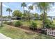 Lush front lawn with tropical landscaping and a covered carport leading to the home at 14124 Kulig Ct, Hudson, FL 34667