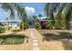 Charming home featuring a swing, stone pathway, and lush tropical landscaping at 14124 Kulig Ct, Hudson, FL 34667