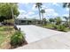 Charming single-story home with a covered carport and large concrete driveway with tropical landscaping at 14124 Kulig Ct, Hudson, FL 34667