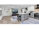 Modern open kitchen with a gray island, stainless steel appliances, and a view of the living area at 14124 Kulig Ct, Hudson, FL 34667