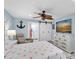 Bedroom featuring light blue walls, TV, ceiling fan, and ensuite bathroom with barn door access at 14124 Kulig Ct, Hudson, FL 34667