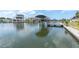 Waterfront view featuring a boat dock with boat lift and nearby homes along the canal at 14124 Kulig Ct, Hudson, FL 34667