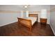 Cozy bedroom with wood laminate flooring, a classic wood bed frame, and bright natural light at 4649 Westerly Dr, New Port Richey, FL 34653