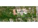 Expansive property featuring a tennis court, pool, and circular driveway amidst lush greenery, creating a private oasis at 10030 Orchard Way, Spring Hill, FL 34608