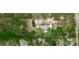 Aerial view of the property showing the house, pool, garage, extra building, and surrounding landscaping at 10030 Orchard Way, Spring Hill, FL 34608