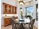Bright breakfast nook features glass table and views of outdoor entertaining space at 10030 Orchard Way, Spring Hill, FL 34608