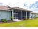 Exterior view of a screened patio featuring a comfortable seating area and well-manicured lawn at 10030 Orchard Way, Spring Hill, FL 34608