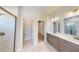 Modern bathroom with dual sinks, sleek vanity, a glass enclosed shower and walk in closet at 10123 Zennia Ln, Parrish, FL 34219