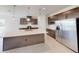 Contemporary kitchen featuring stainless steel refrigerator, sleek cabinetry, and a spacious island with sink at 10127 Zennia Ln, Parrish, FL 34219