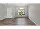 Light-filled dining room with wood-look floors, white trim, and a window overlooking the front yard at 13094 Tailorbird Ave, Brooksville, FL 34614