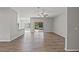 Open living room featuring wood-look flooring, neutral walls, and sliding glass doors to the backyard at 13094 Tailorbird Ave, Brooksville, FL 34614