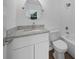 Well-lit bathroom with a granite countertop, white cabinets, and a circular mirror at 5173 Pacific Ave, Spring Hill, FL 34607