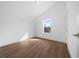 Bright, empty bedroom with hardwood floors and a window overlooking greenery at 5173 Pacific Ave, Spring Hill, FL 34607