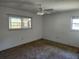 This is a bedroom with neutral paint, a ceiling fan, and natural light from the windows at 12501 Shadow Ridge Blvd, Hudson, FL 34669