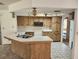 Open kitchen featuring laminate countertops, wood cabinets, an island, and an undermount sink at 12501 Shadow Ridge Blvd, Hudson, FL 34669