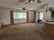 Open floor plan featuring a carpeted living room with a ceiling fan and sliding door access to the backyard at 12501 Shadow Ridge Blvd, Hudson, FL 34669