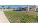 Well-manicured backyard featuring a spacious lawn, covered patio, and a charming white picket fence at 13705 Allyn Dr, Hudson, FL 34667