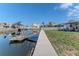 Waterfront backyard with a dock, grassy lawn, and canal views, offering a serene and private setting at 13705 Allyn Dr, Hudson, FL 34667