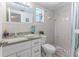 Updated bathroom with granite countertops, white cabinets, and a tiled shower at 13705 Allyn Dr, Hudson, FL 34667