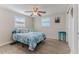 Cozy bedroom featuring a ceiling fan, wood floors, and natural light streaming through the windows at 13705 Allyn Dr, Hudson, FL 34667