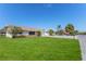 Single-story home with a manicured lawn, mature trees, and attached garage on a sunny day at 13705 Allyn Dr, Hudson, FL 34667