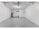 Spacious garage with concrete floor, overhead door, utility sink, and water heater at 13705 Allyn Dr, Hudson, FL 34667