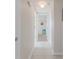 Bright hallway with white trim and tile floors leads to sunlit rooms, enhancing the home's open feel at 13705 Allyn Dr, Hudson, FL 34667