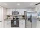 Modern kitchen with stainless steel appliances, granite counters, and white cabinetry at 13705 Allyn Dr, Hudson, FL 34667